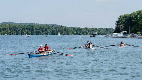 Drei Boote mit jeweils zwei Menschen auf dem Wasser. 