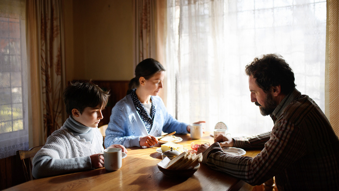 Familie sitzt am Frühstückstisch