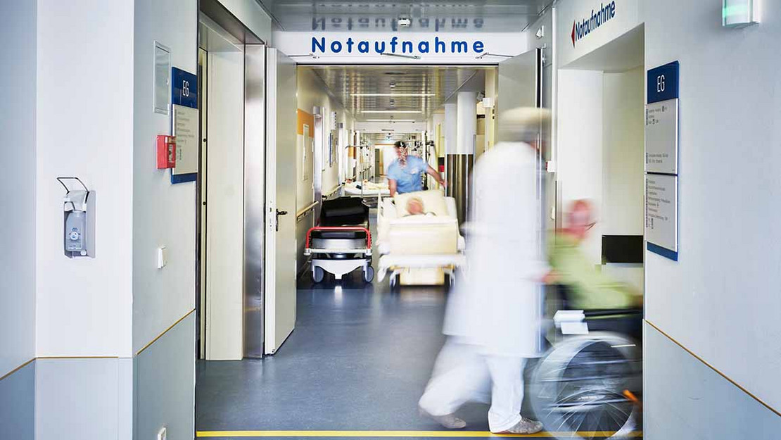 Flur einer Notaufnahme mit Medizinern und Patienten